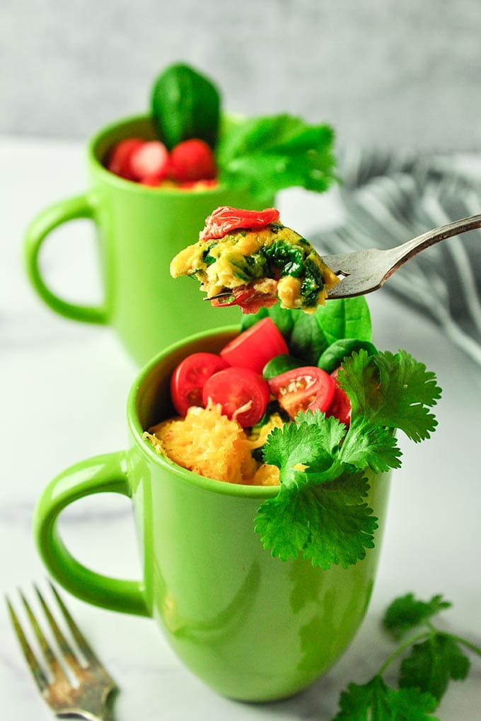 omelette in a green mug, topped with veggies