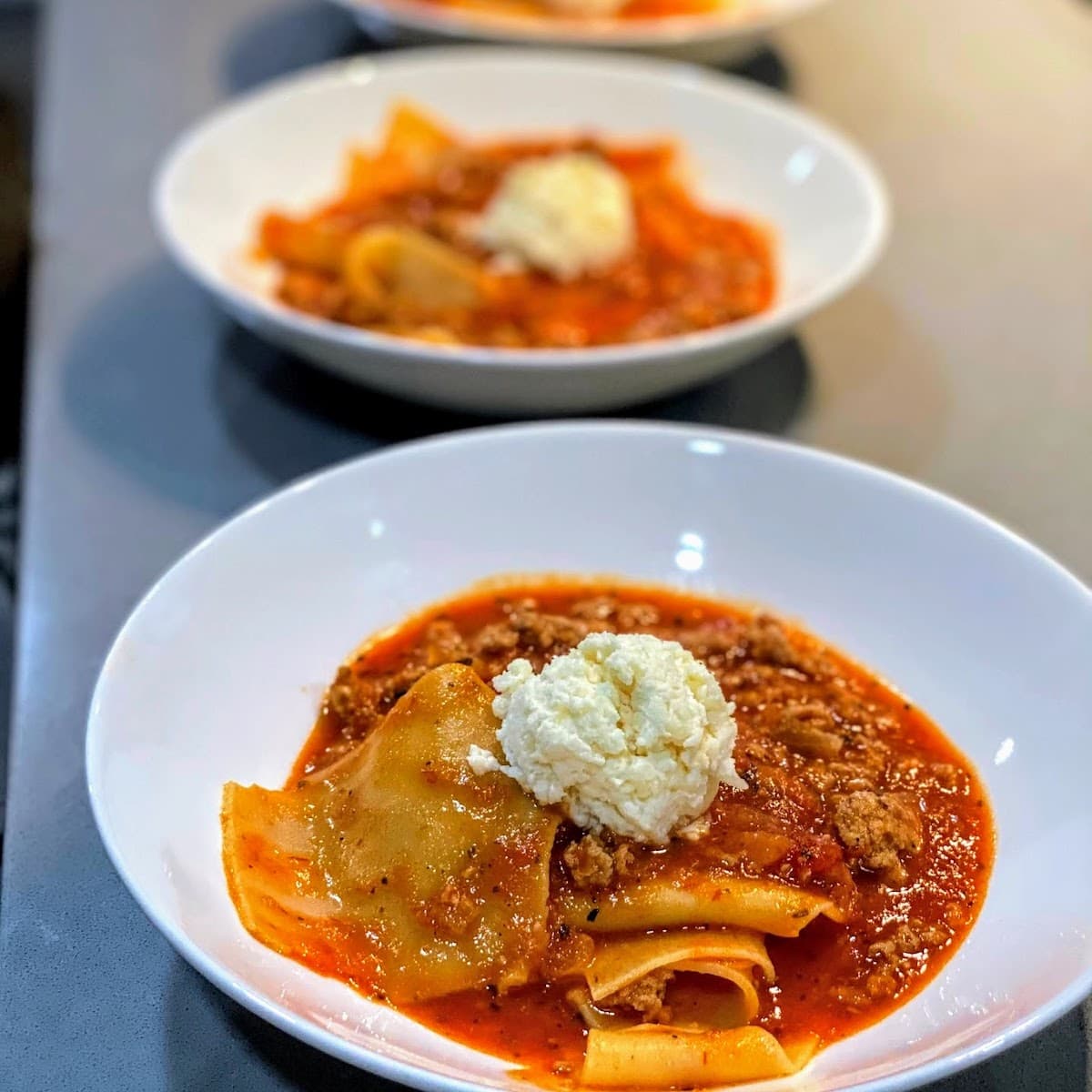 lasagna soup topped with scoop of cheese