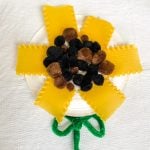 paper plate sunflower made from lasagna noodles and pompoms 