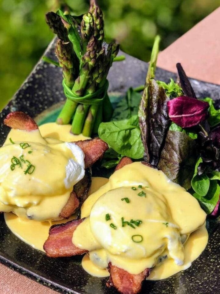 eggs benedict with bacon, asparagus, and mixed greens