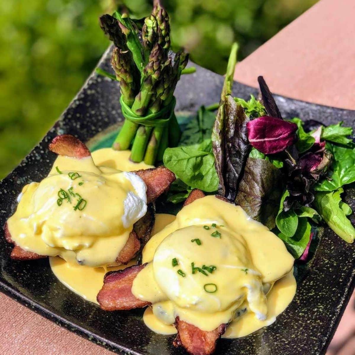 eggs benedict with bacon, asparagus, and mixed greens