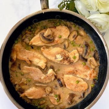 Marsala chicken with mushrooms and peas in pan
