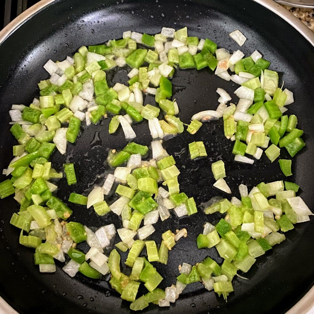 cucumber, onion, garlic and peppers cooking in pan