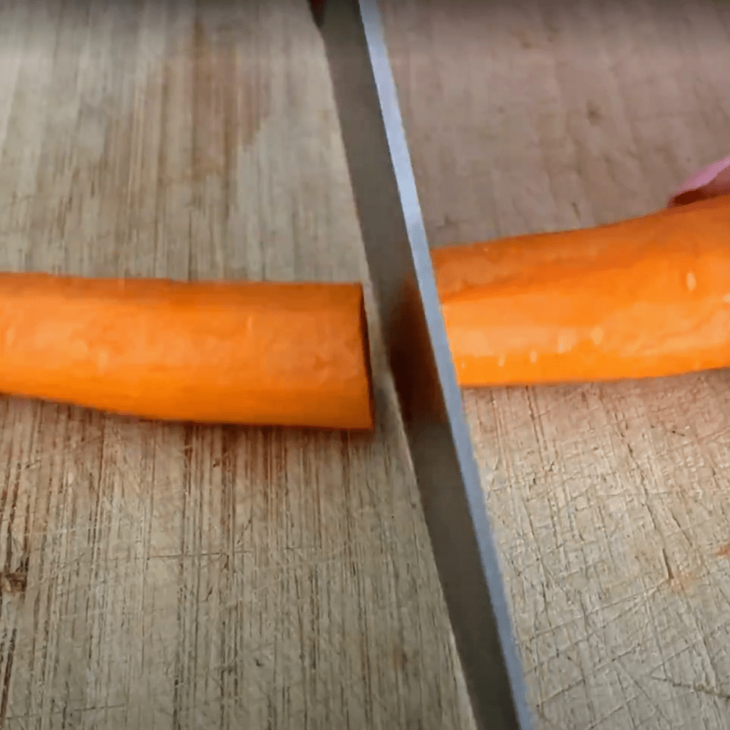 slicing whole carrot in half