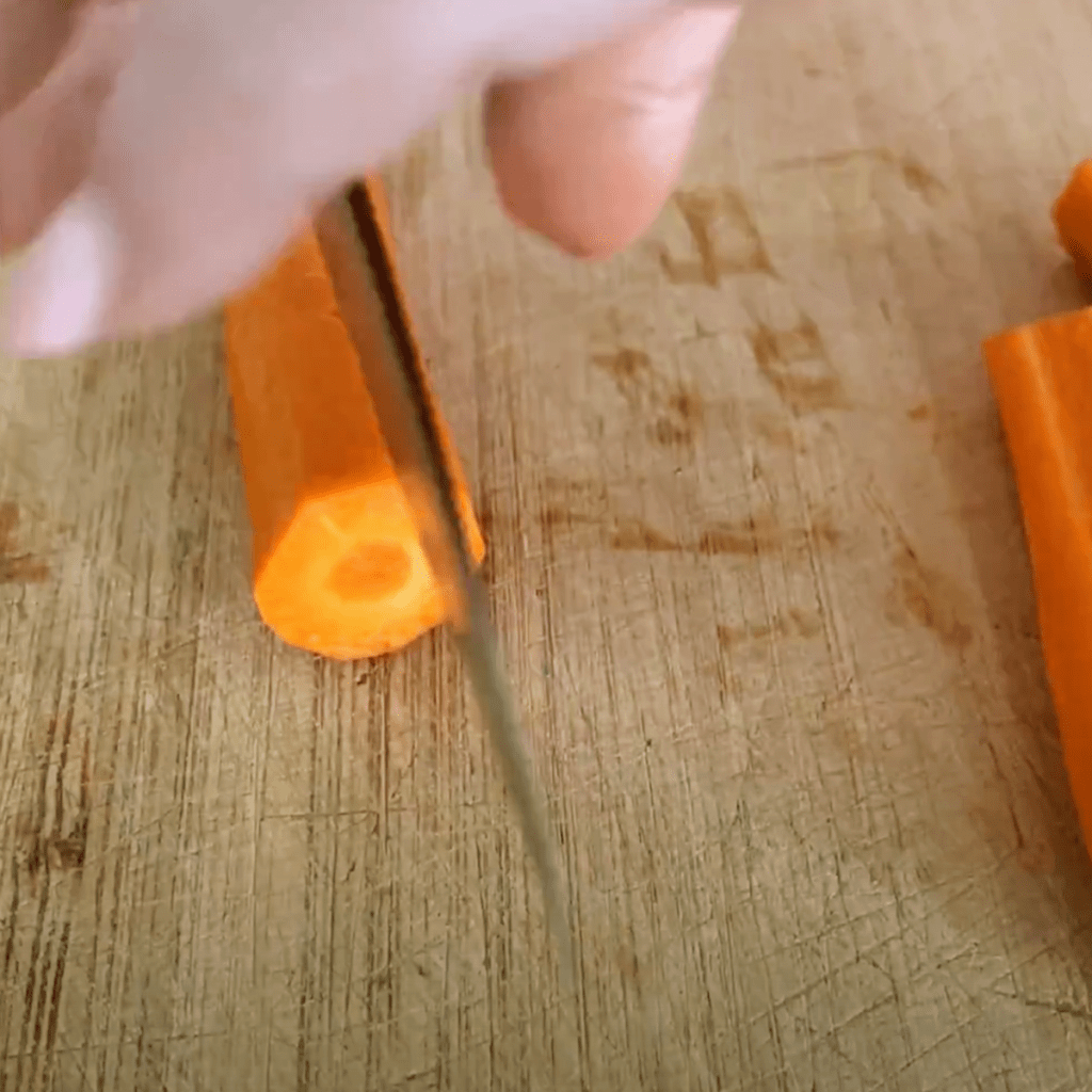 slicing carrot chunks in half