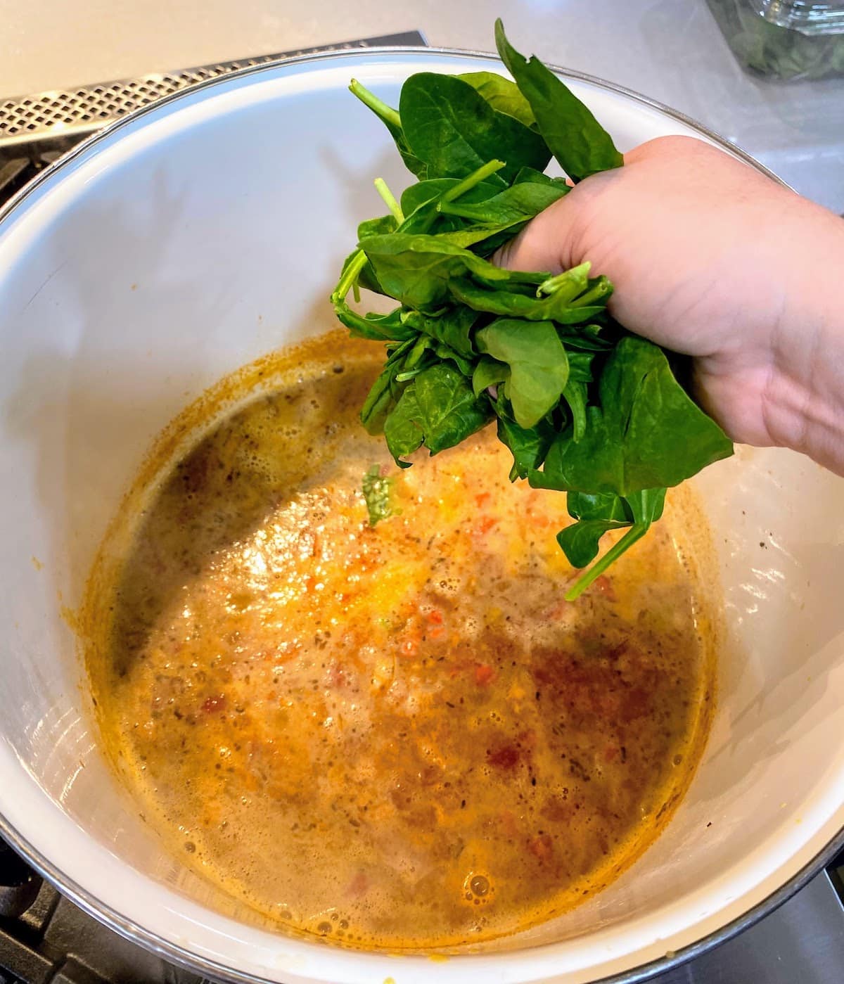 adding spinach to cannellini bean soup