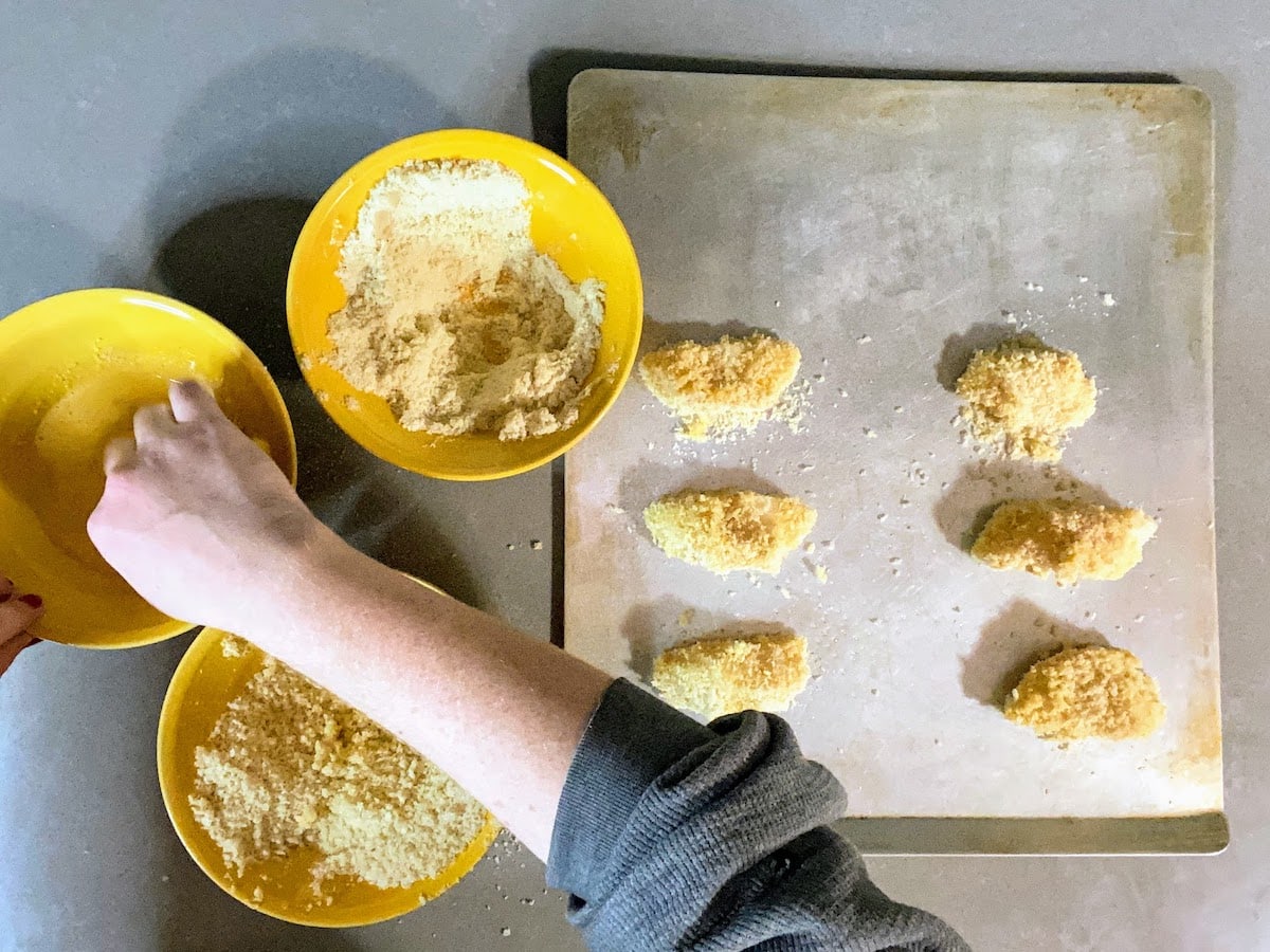 coating pieces of cod fish with flour, eggs and panko