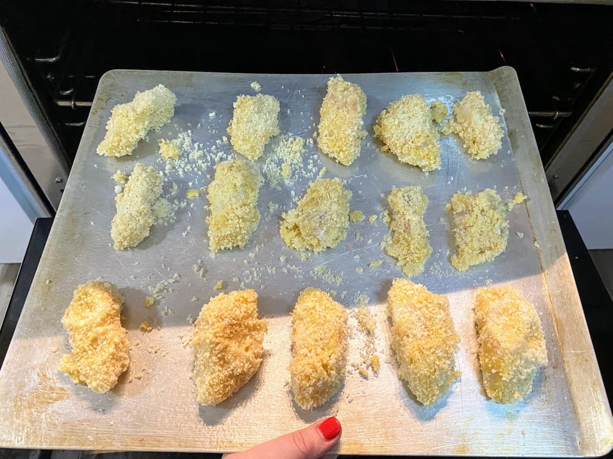 breaded cod on a baking sheet about to go in oven