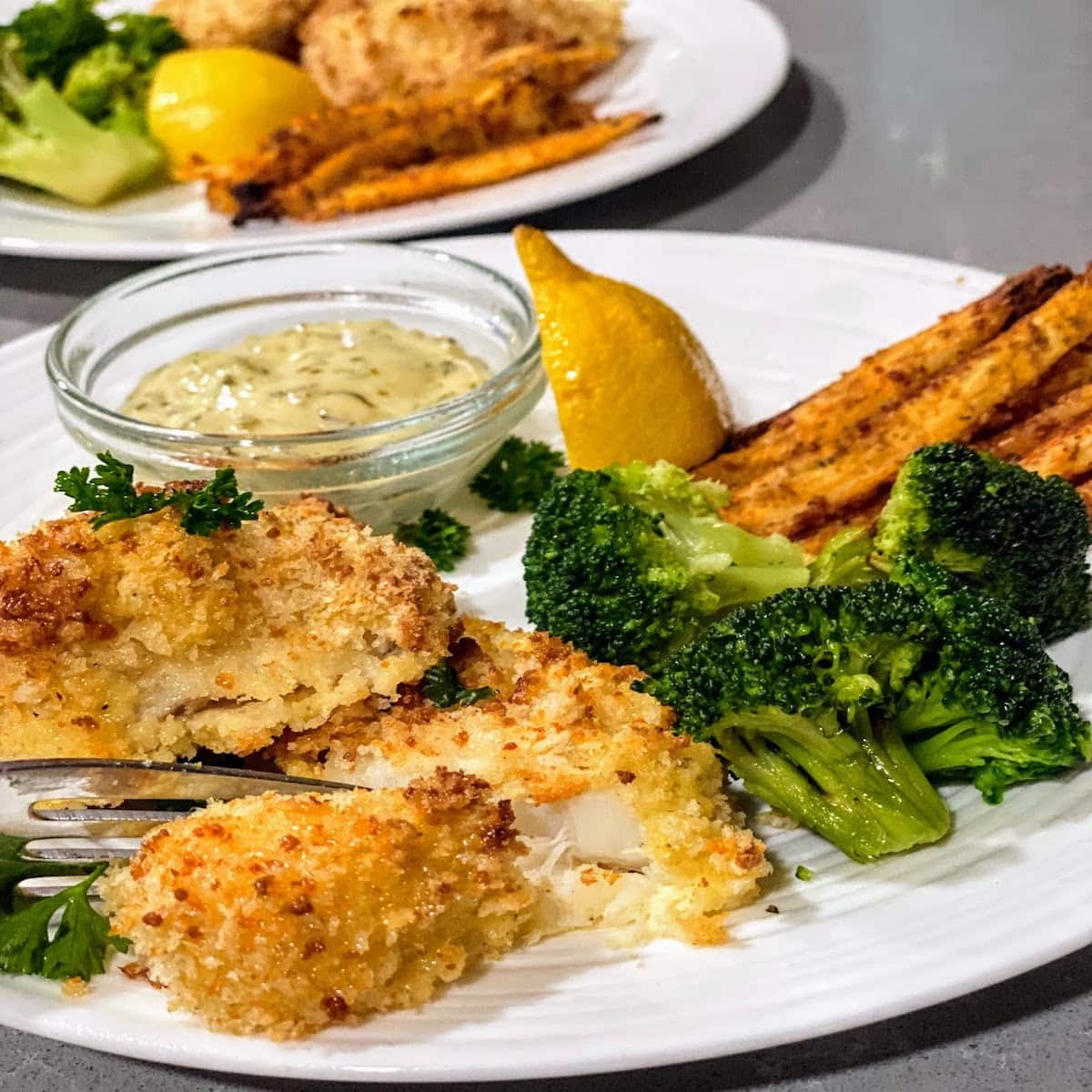 baked white fish with lemon, broccoli and fries