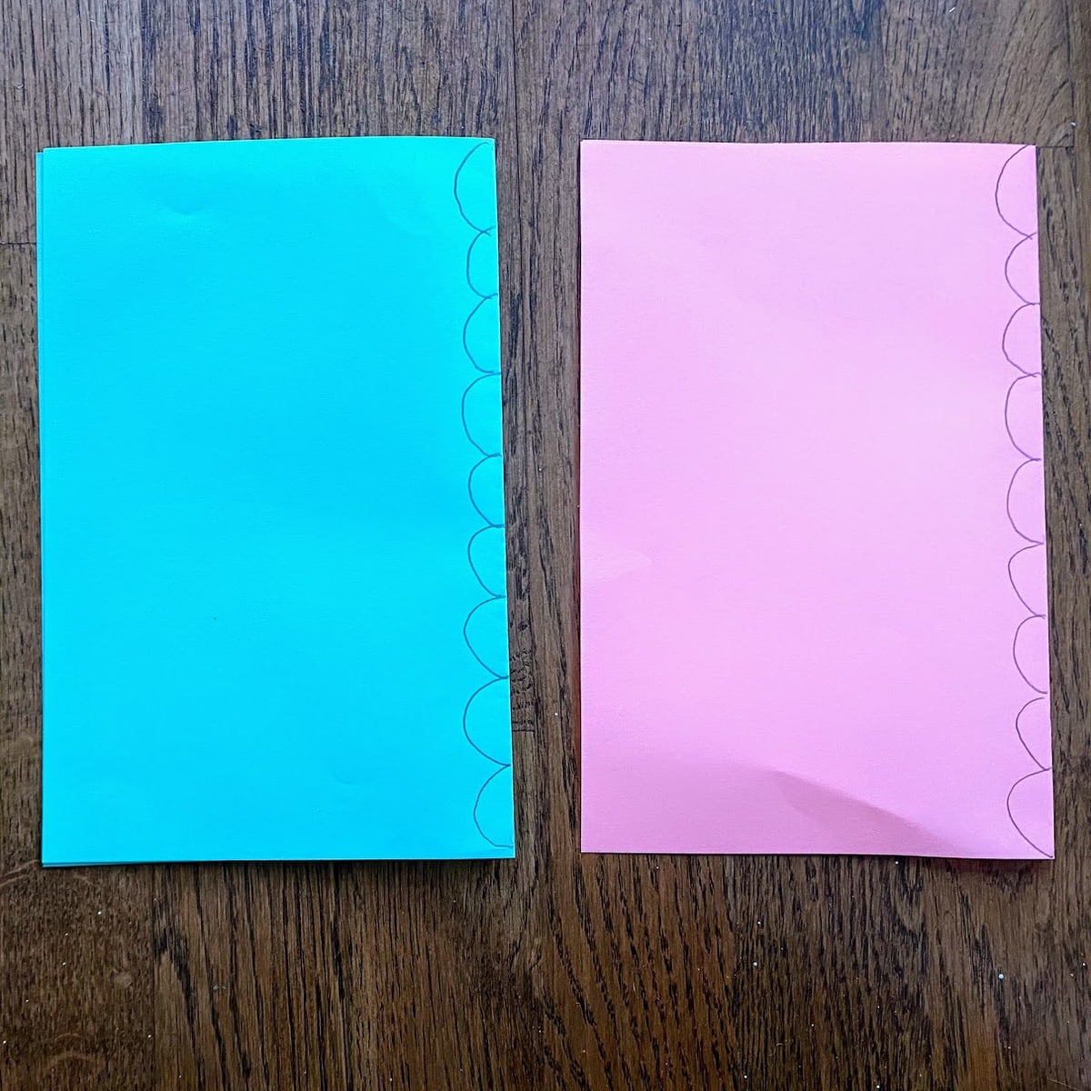 semi circles drawn on folded blue and pink paper