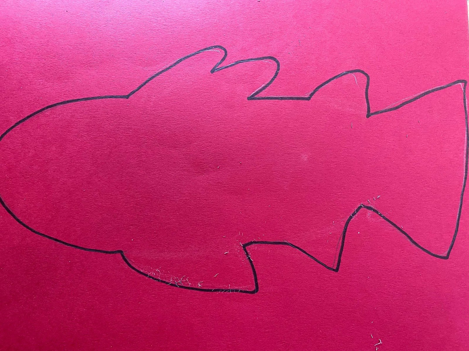 outline of fish on red paper