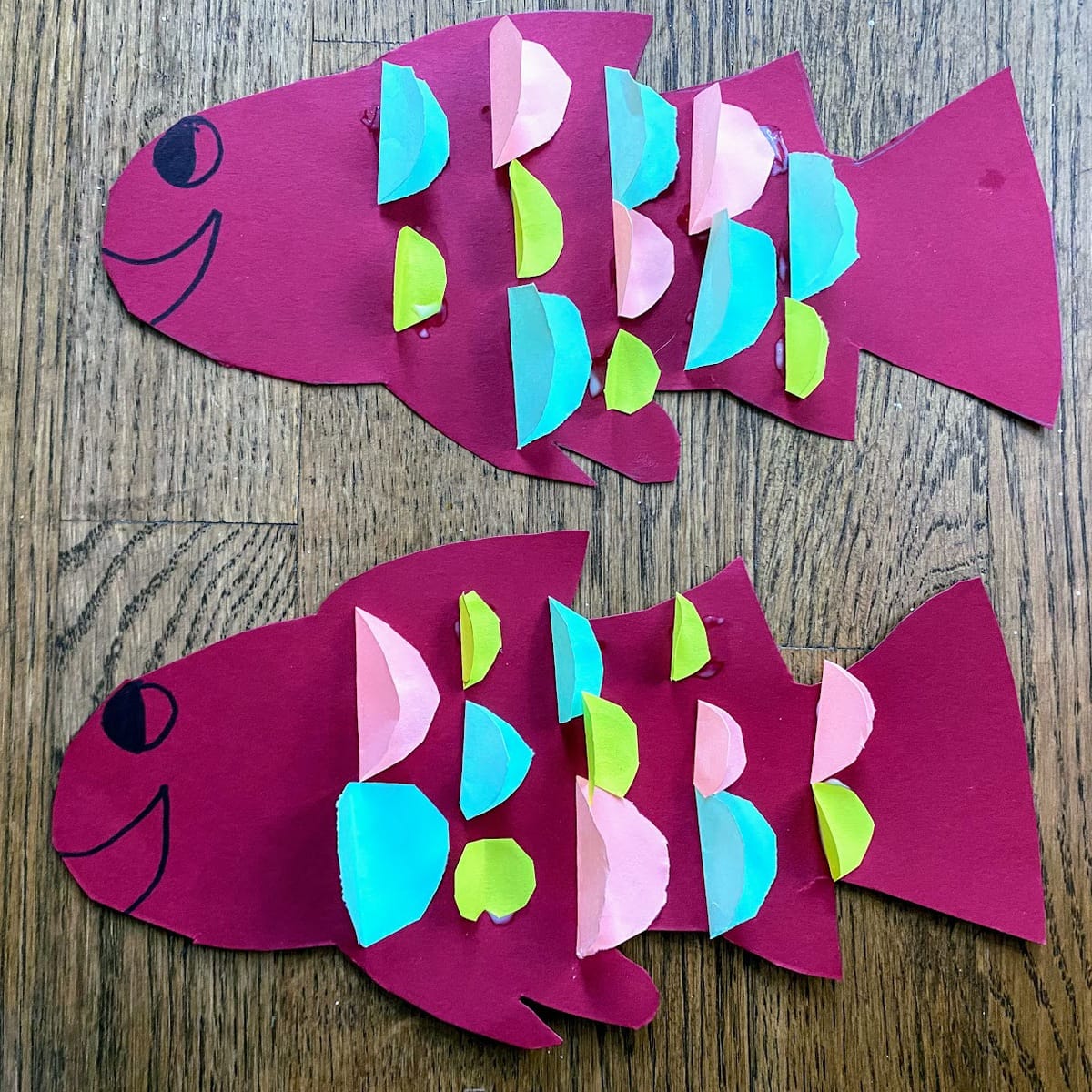 two paper fishes with eyes and mouth drawn on