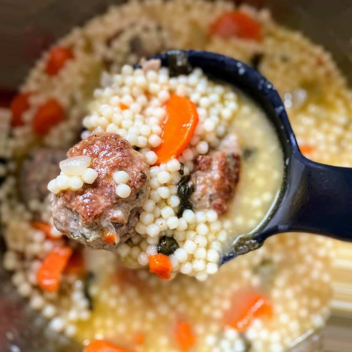 Italian wedding soup in ladle 