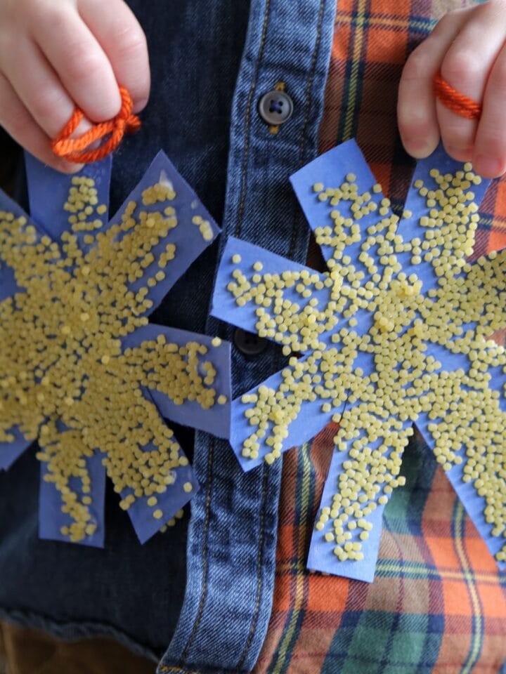 two paper snowflakes with pasta