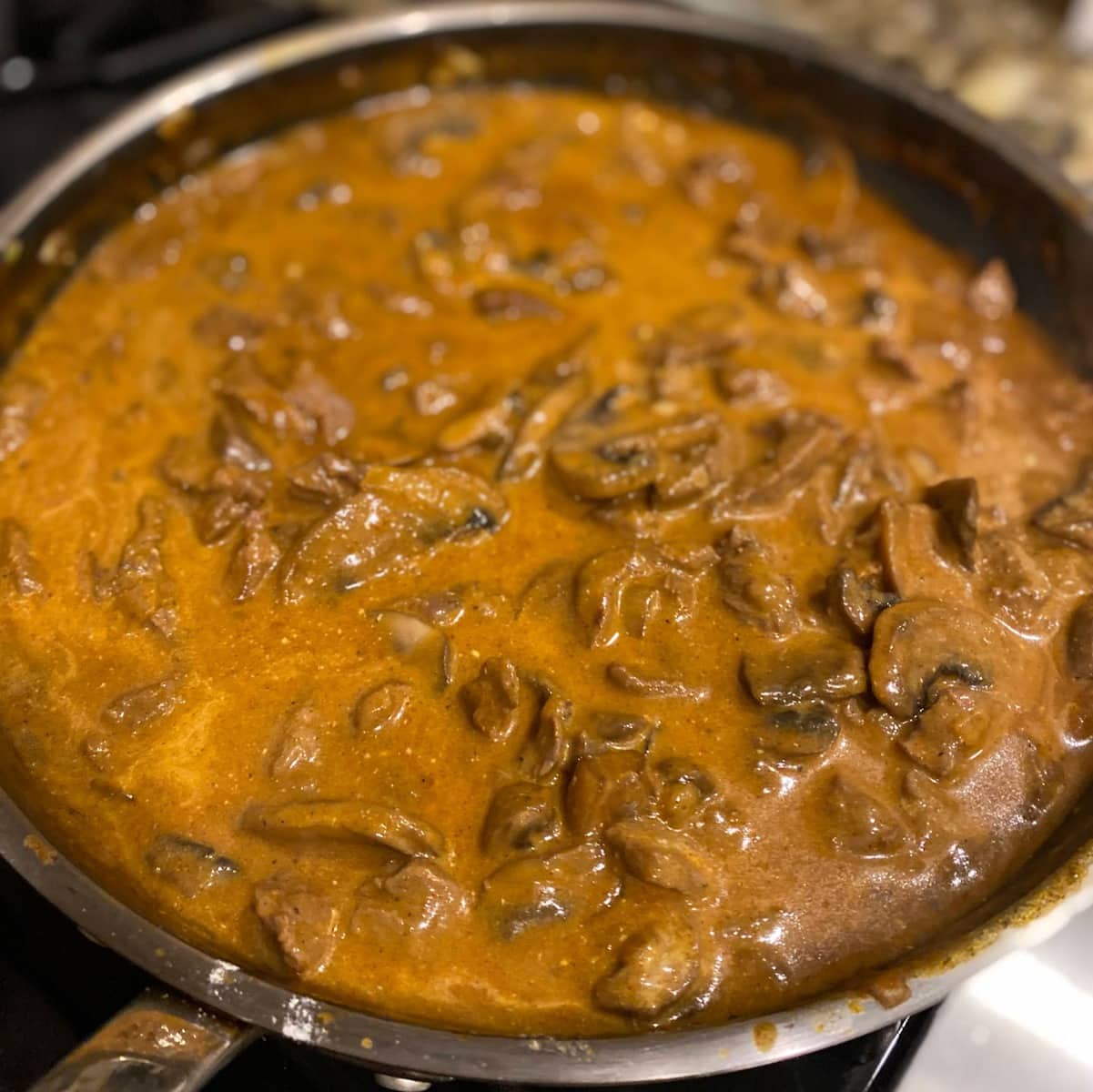 beef with creamy mushroom sauce in pan