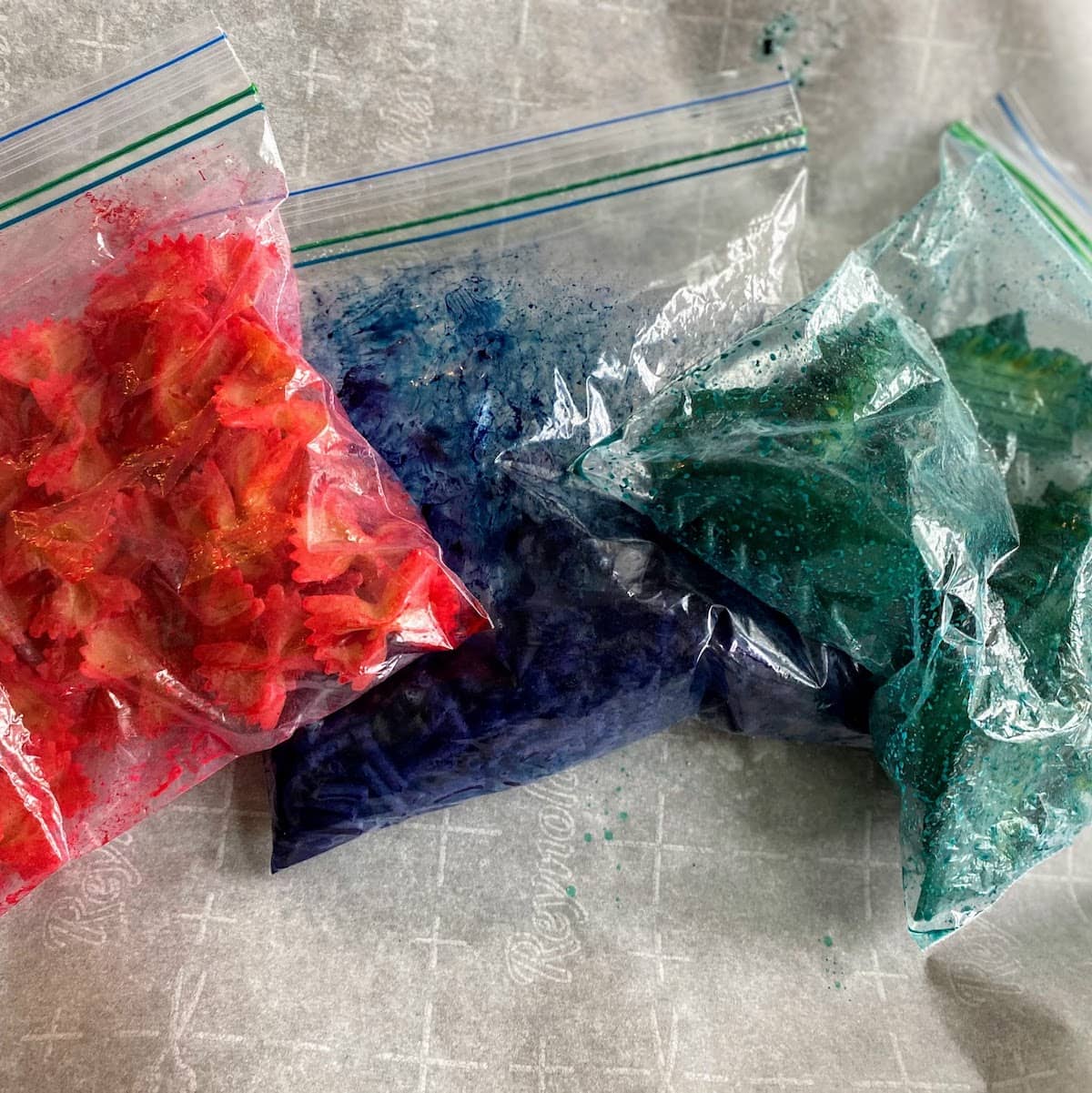 red, blue and green colored pasta in bags