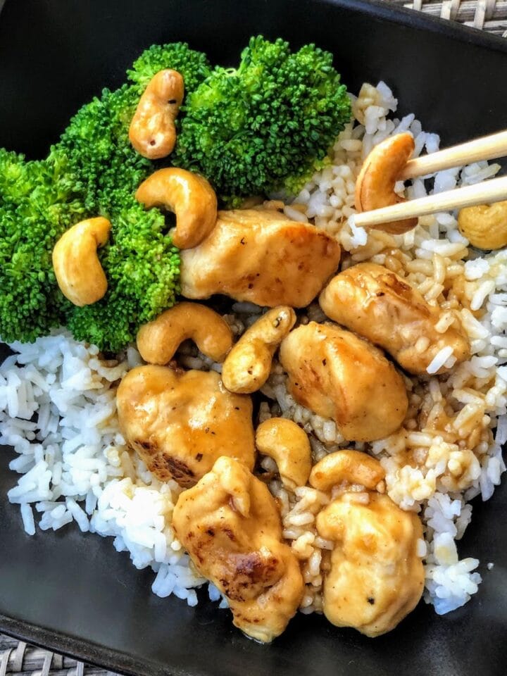 chicken and cashews with chopsticks atop white rice