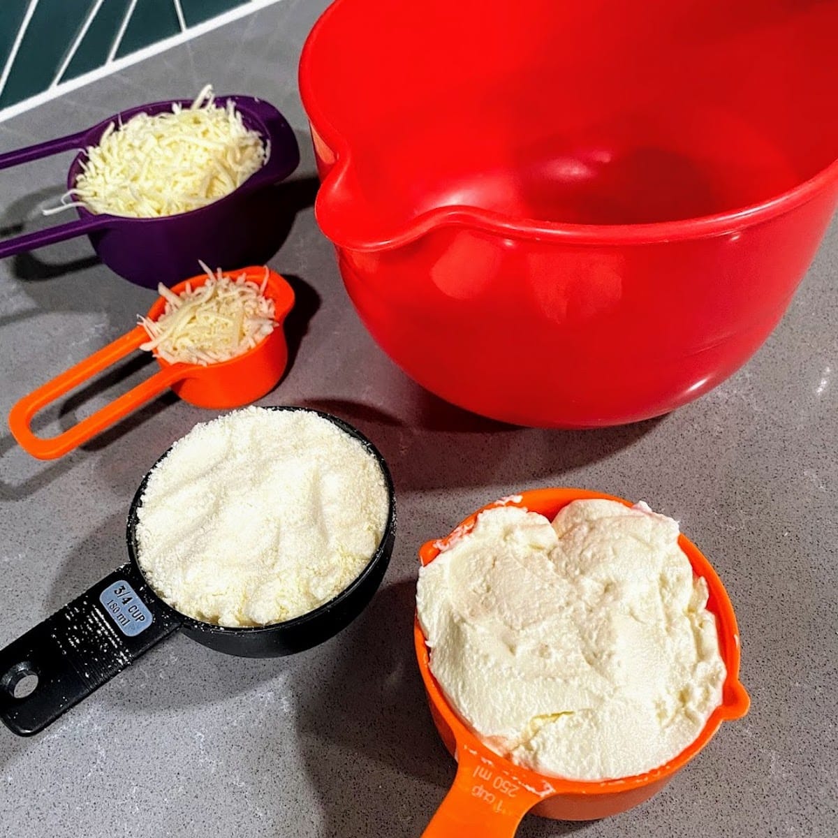 four kinds of cheeses in measuring cups