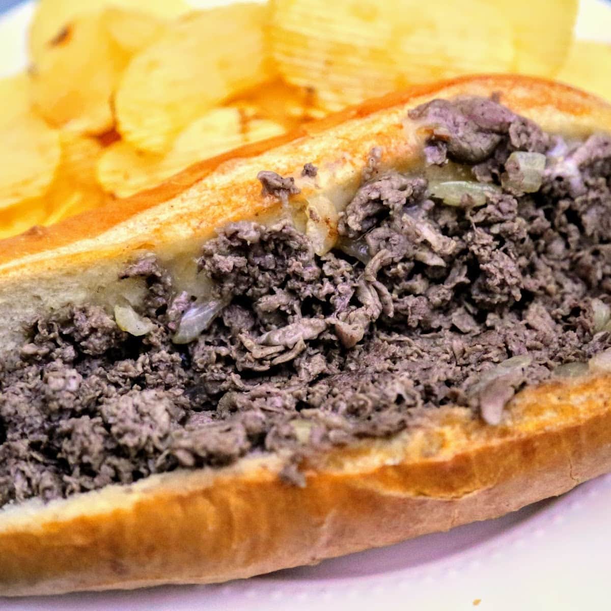 cheesesteak with chips on plate