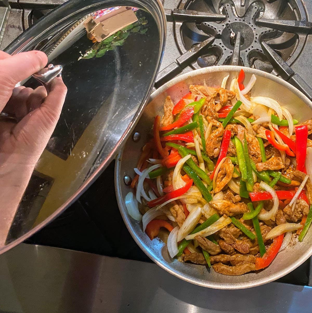 putting lid on pan with chicken and veggies