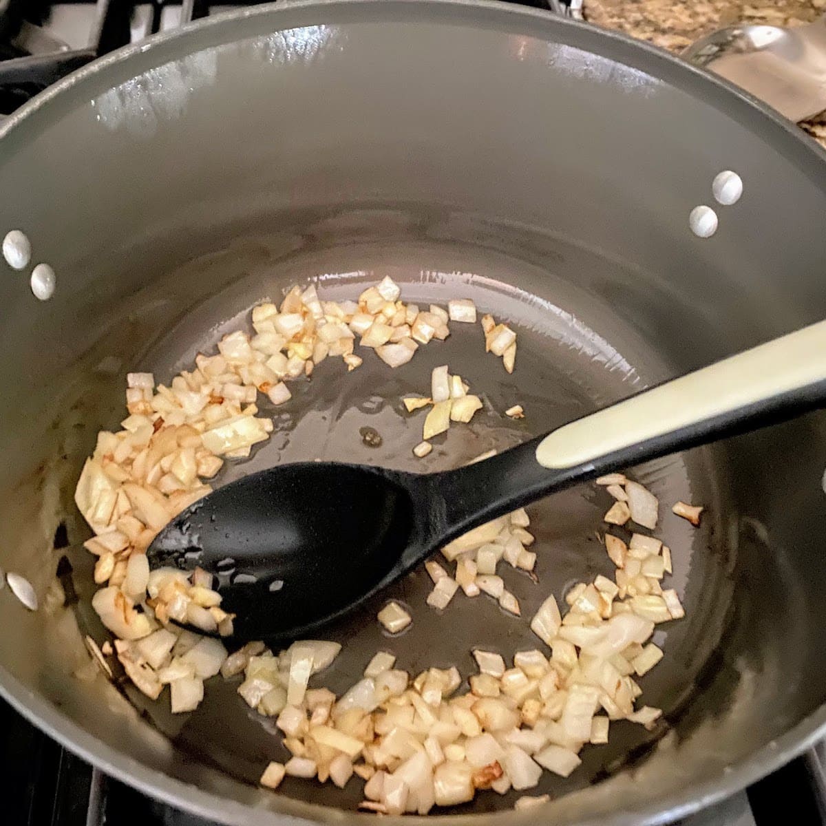 stirring onion and garlic in pot