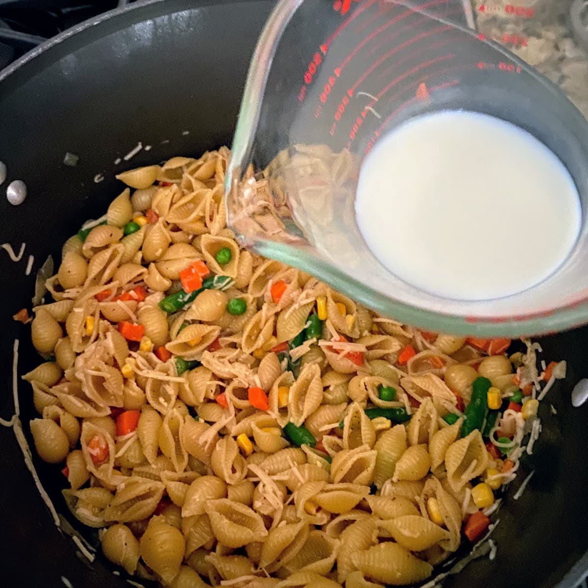 adding milk to pasta
