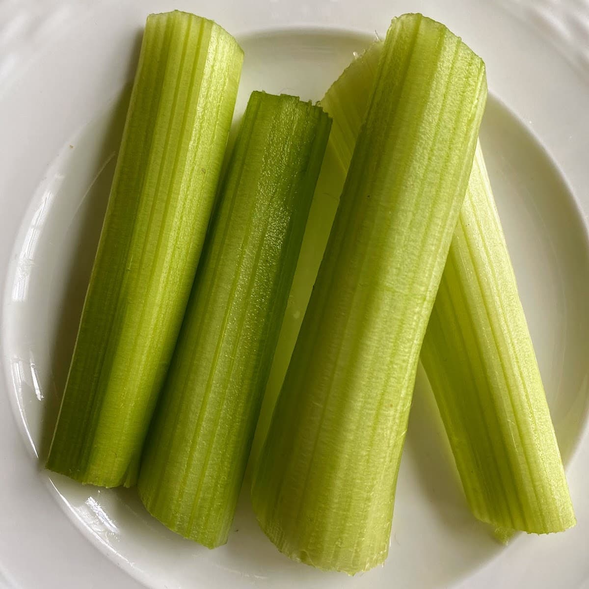 cut celery stalks on white plate