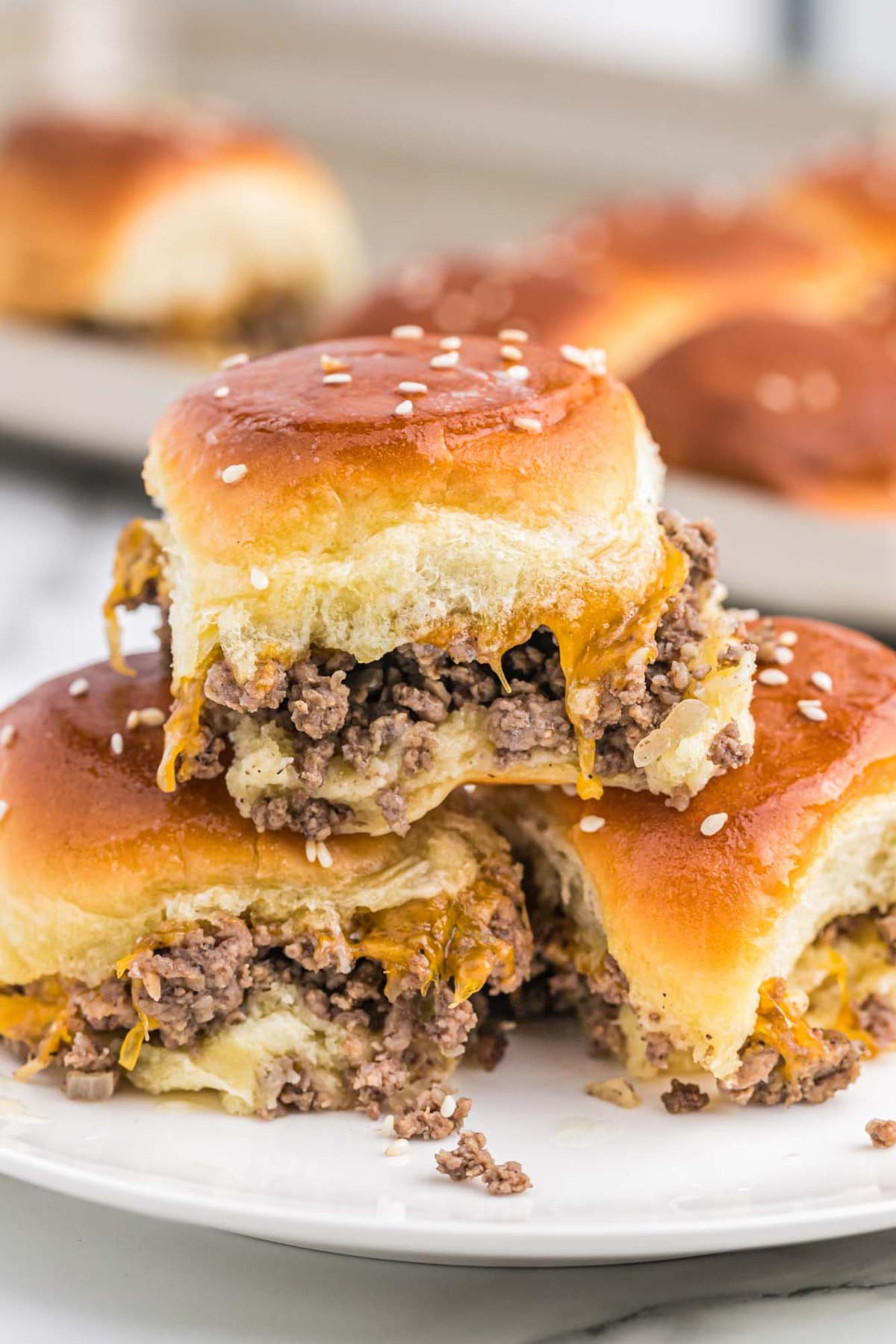 closeup of three cheeseburger sliders with ground beef