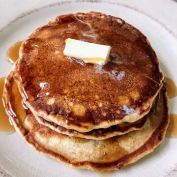 stacked pancakes with butter and syrup on top.