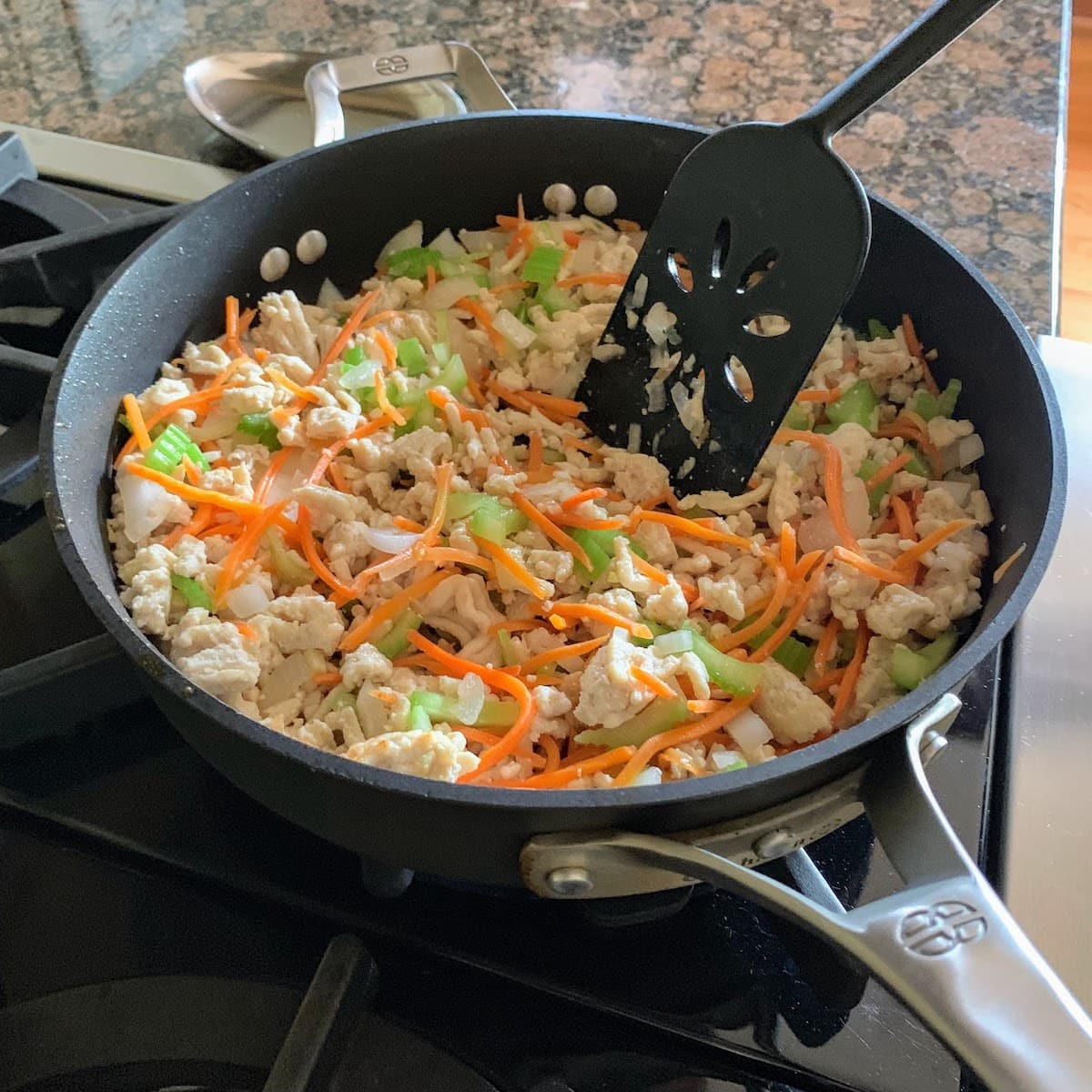 cooking chicken and veggies in pan