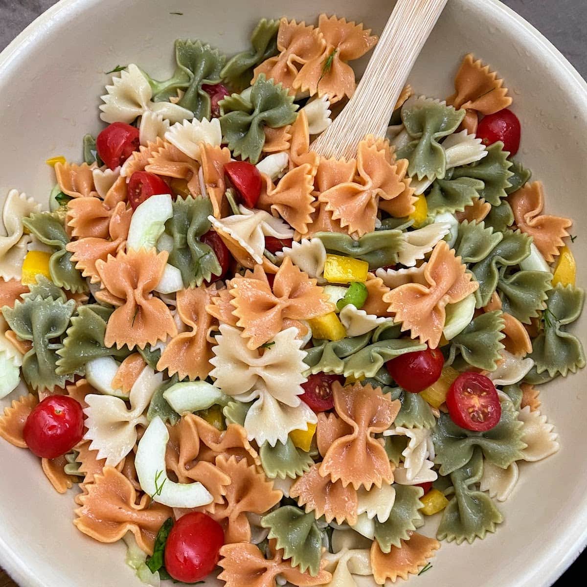 bow tie pasta salad in large bowl with spoon