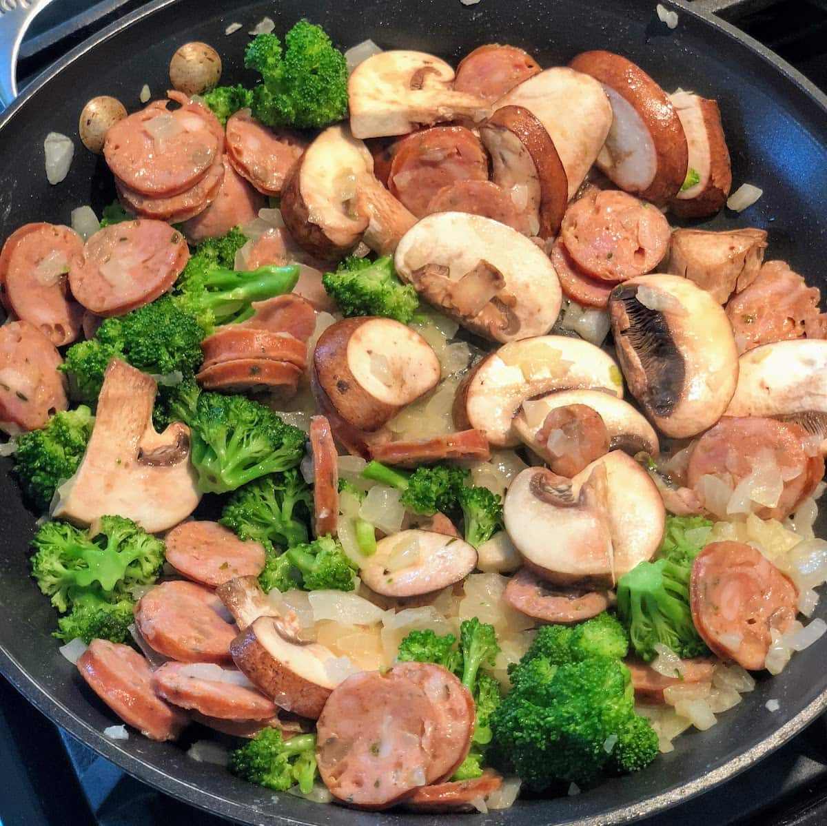 broccoli, mushroom, onion and sausage in pan