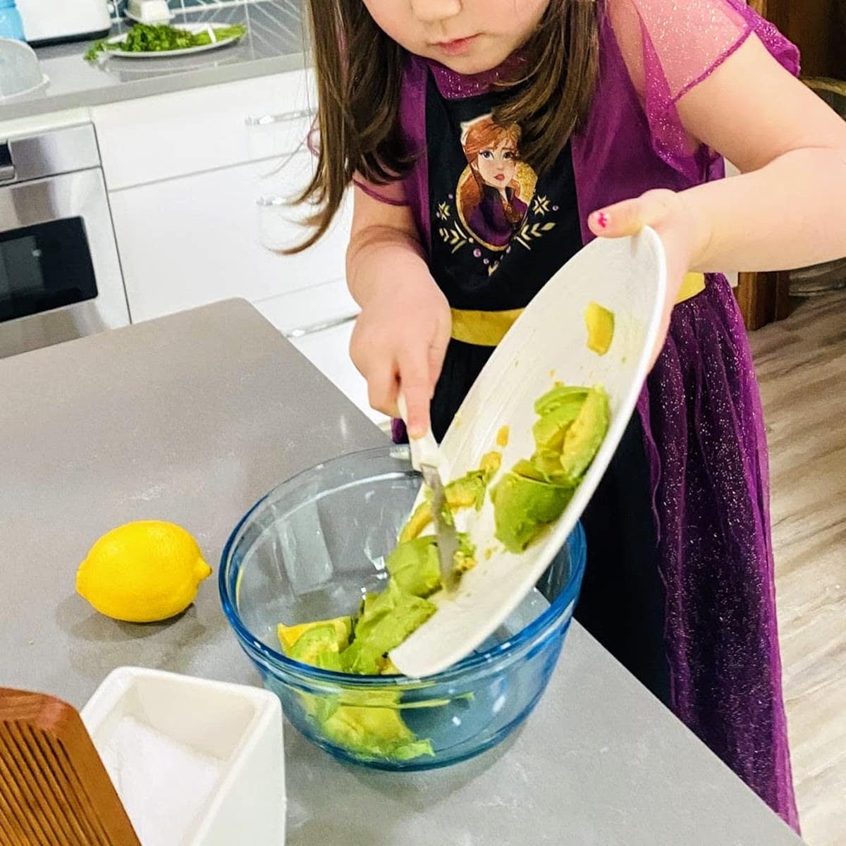 child clearing avocado off plate