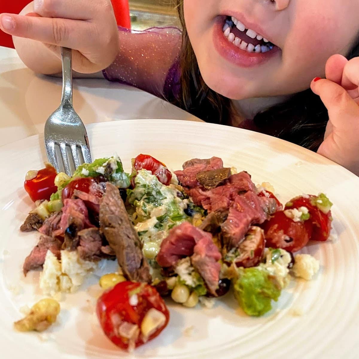 child eating steak with veggies