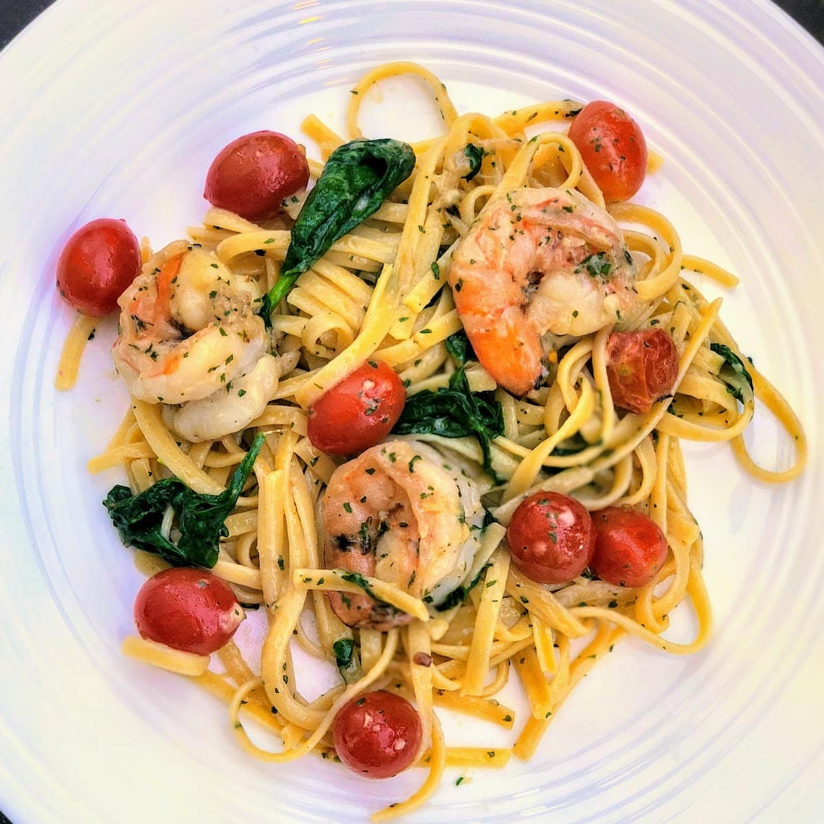 closeup of shrimp pasta on white plate