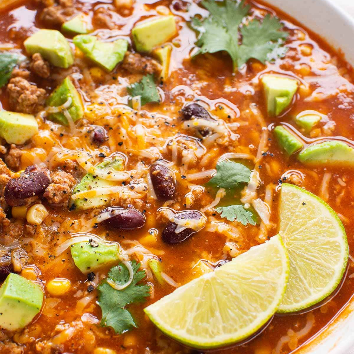 Taco soup with ground turkey and lime in bowl