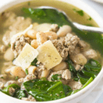 Turkey and White Bean Spinach Soup in white bowl with spoon