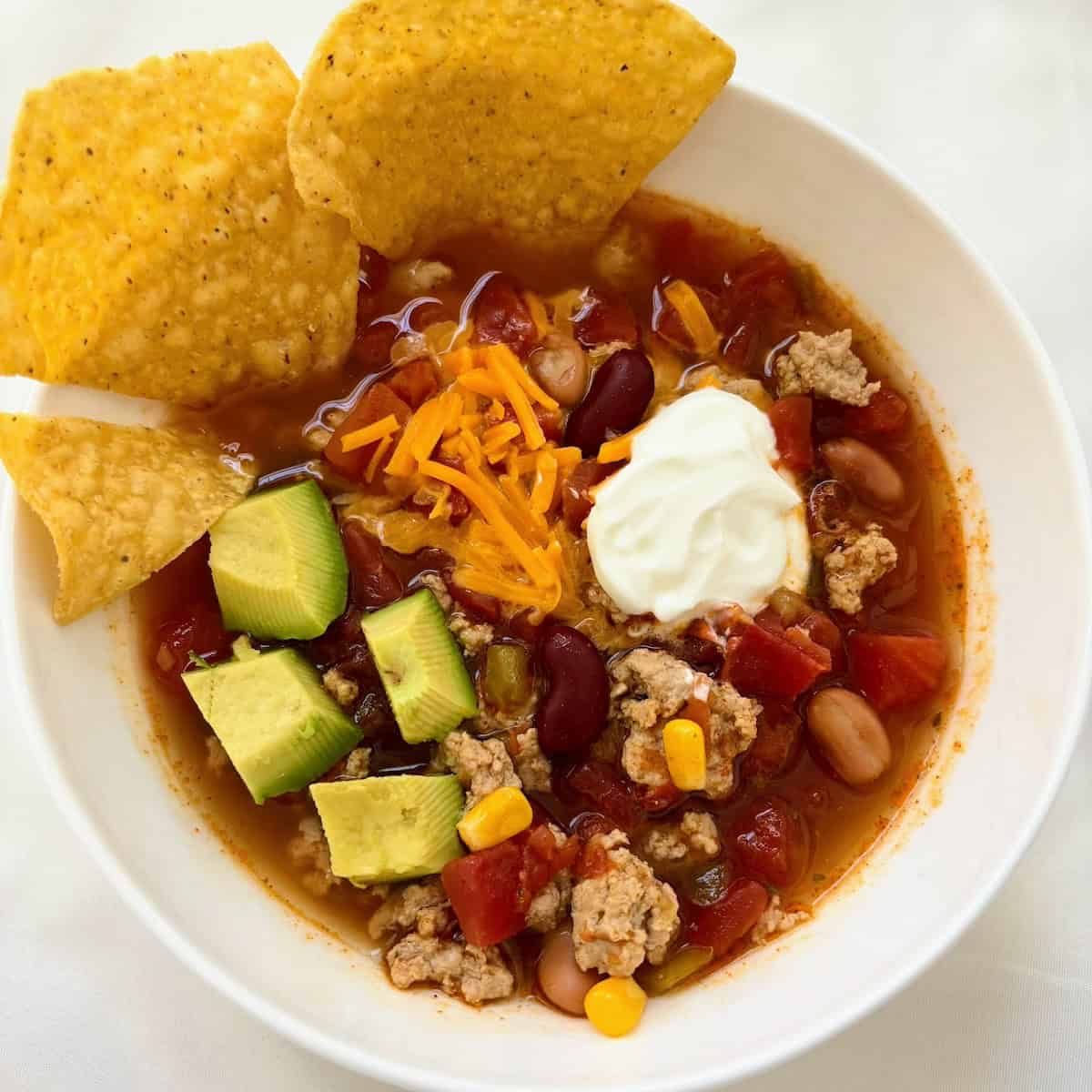 Taco soup in a bowl with toppings. 