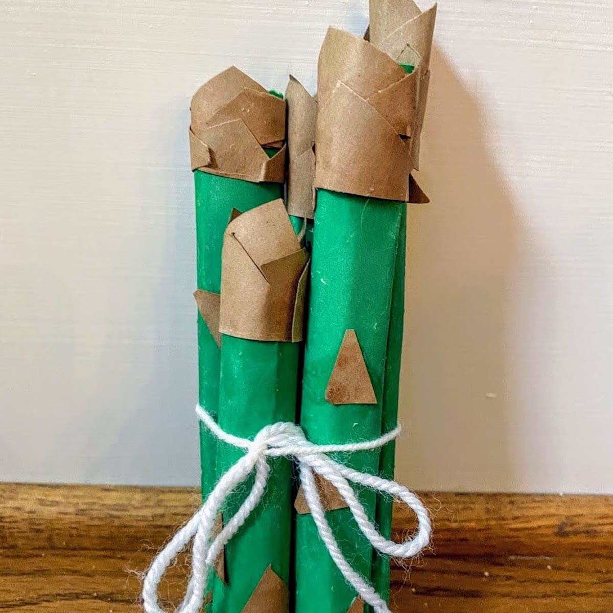 bunch of playfood paper asparagus tied together with a string