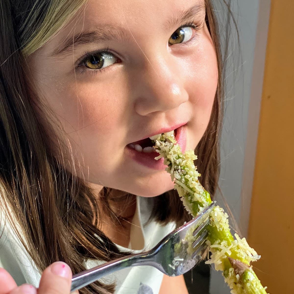 girl eating roasted asparagus