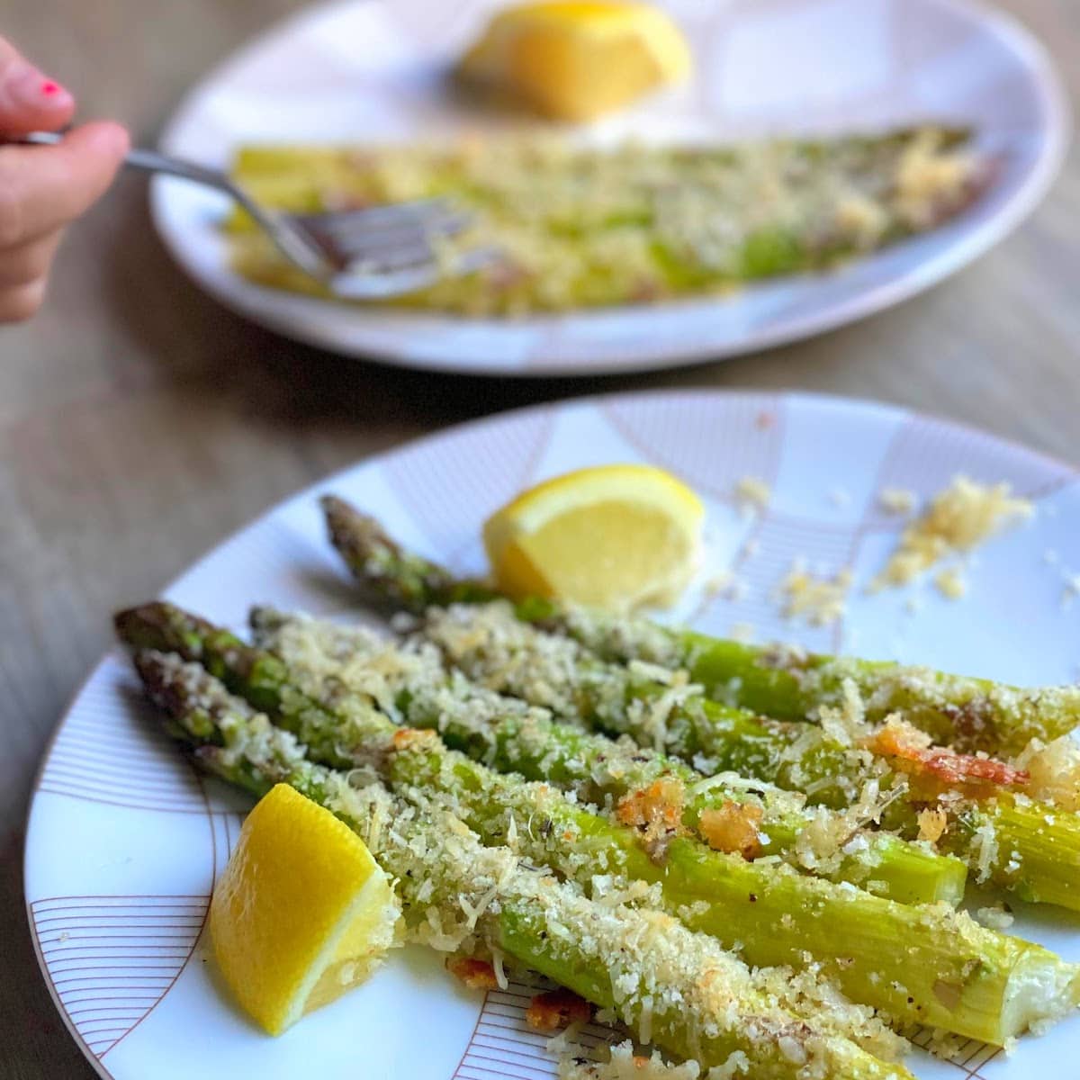 roasted asparagus with parmesan panko crumbles and lemon on plates