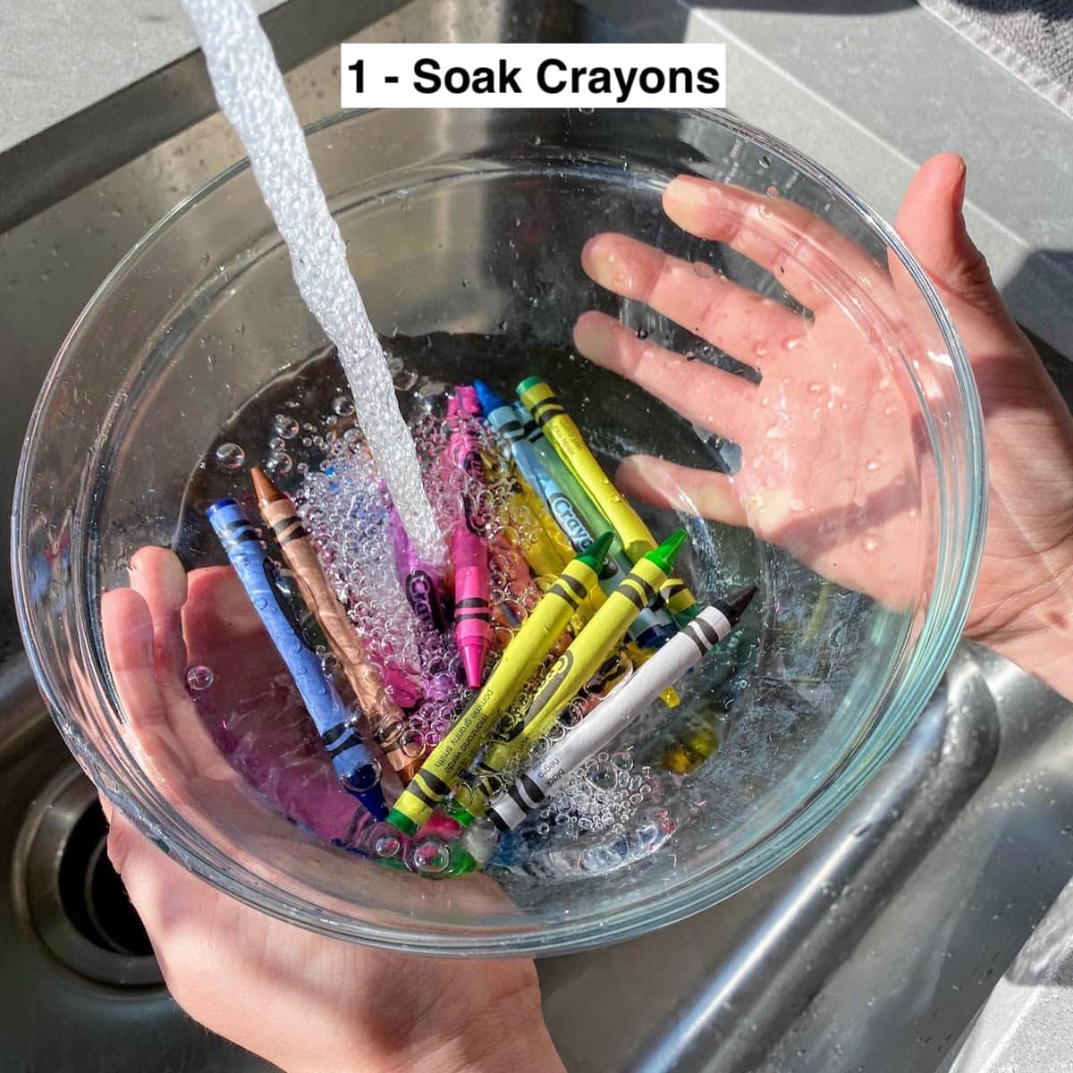 filling a bowl of crayons with water in sink