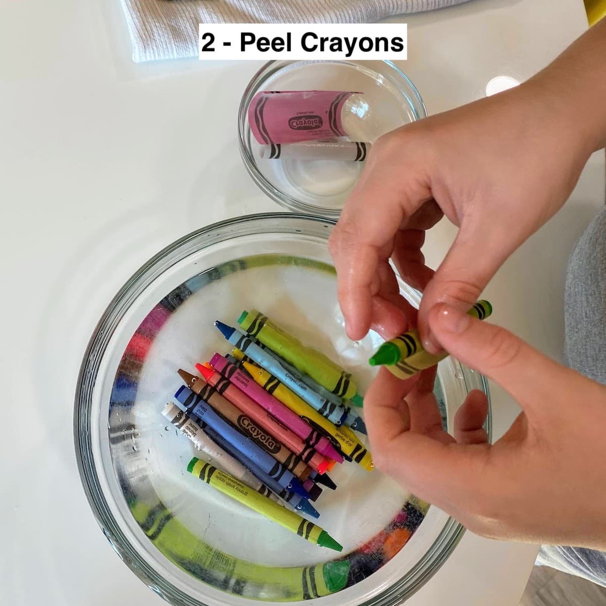 kid hands peeling wrappers off crayons