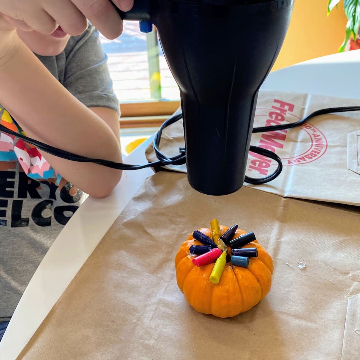 heating crayons on a pumpkin with a blow dryer