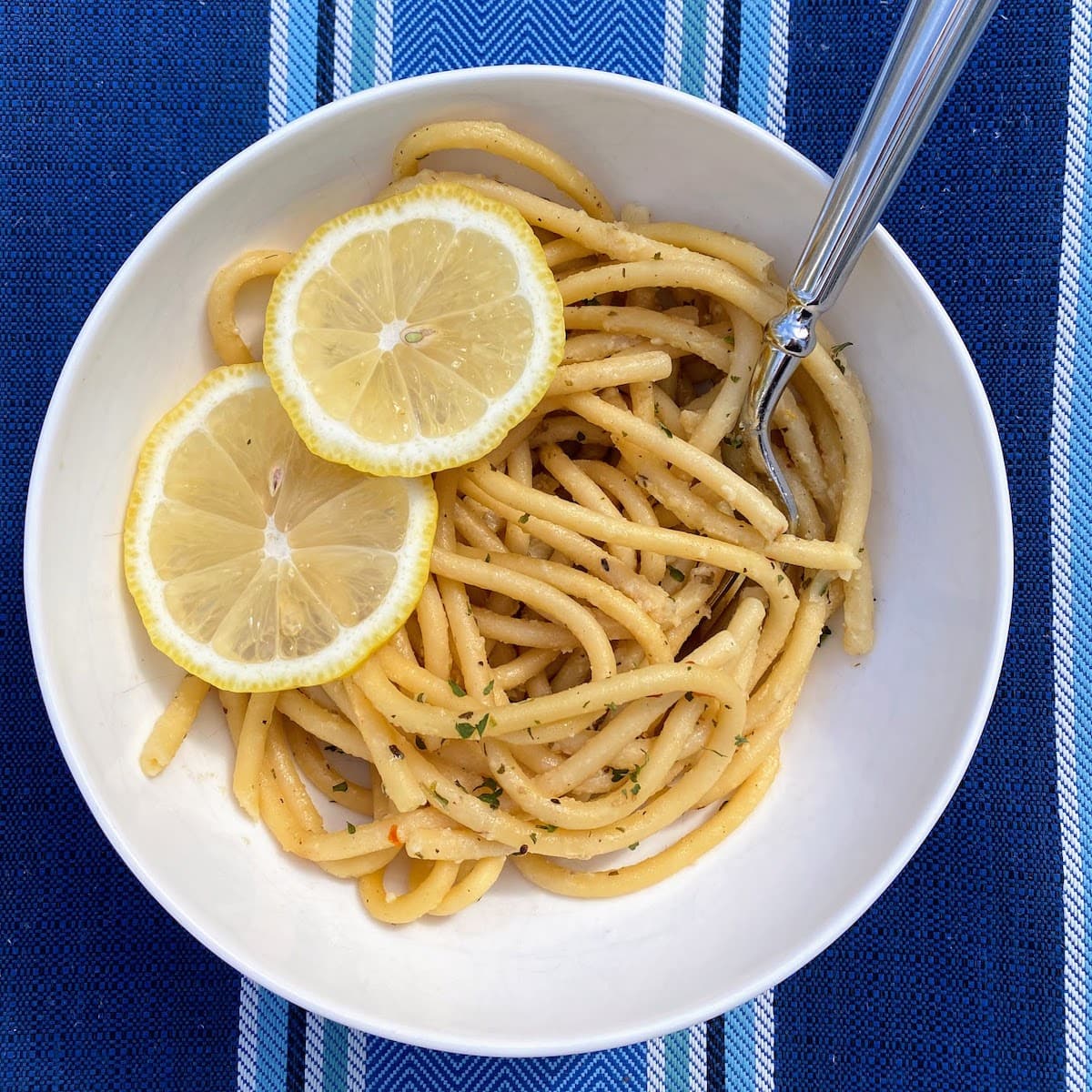 lemon garlic pasta in bowl with sliced lemons