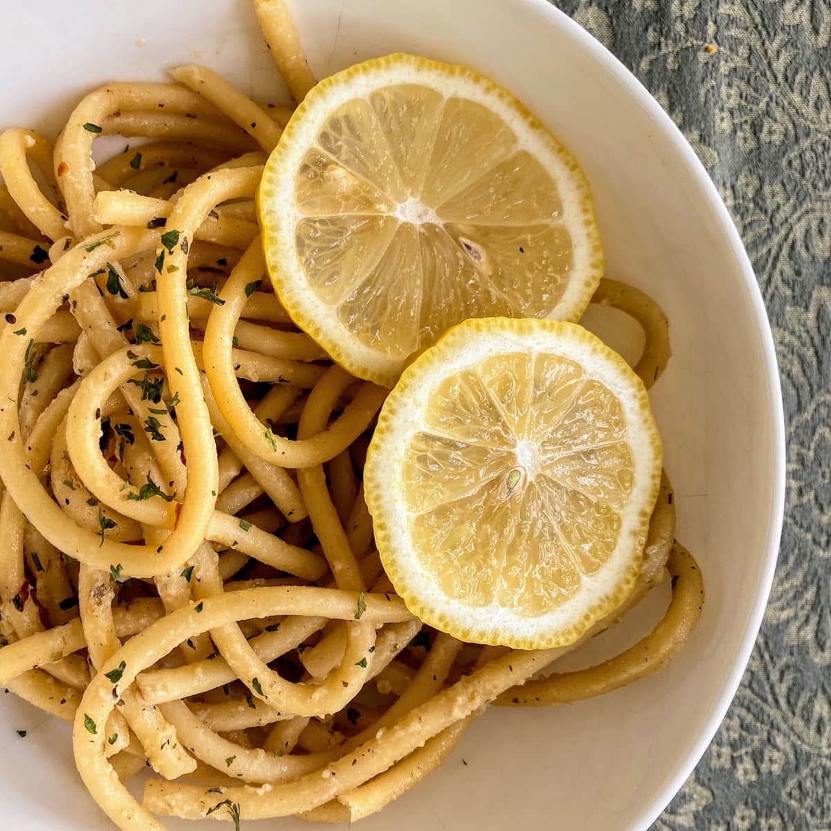 lemon garlic pasta in bowl with lemon slices 