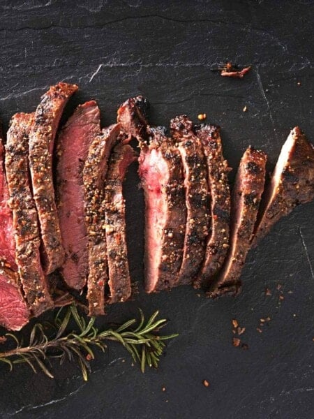 cut and seasoned steak with rosemary