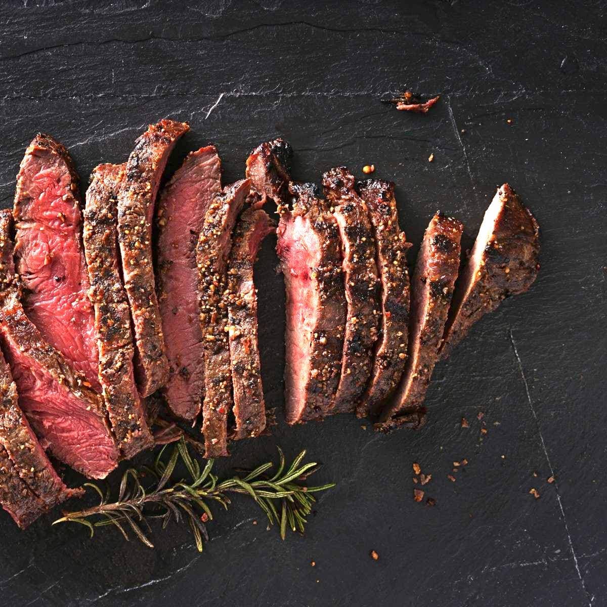 cut and seasoned steak with rosemary