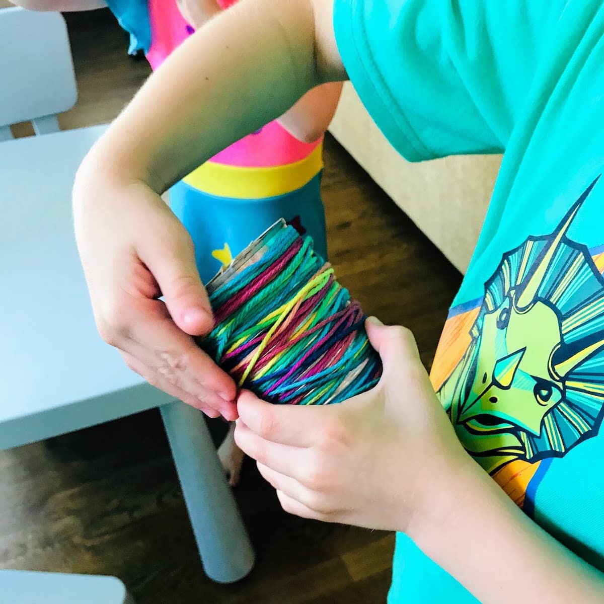 wrapping colorful yarn around a tin can