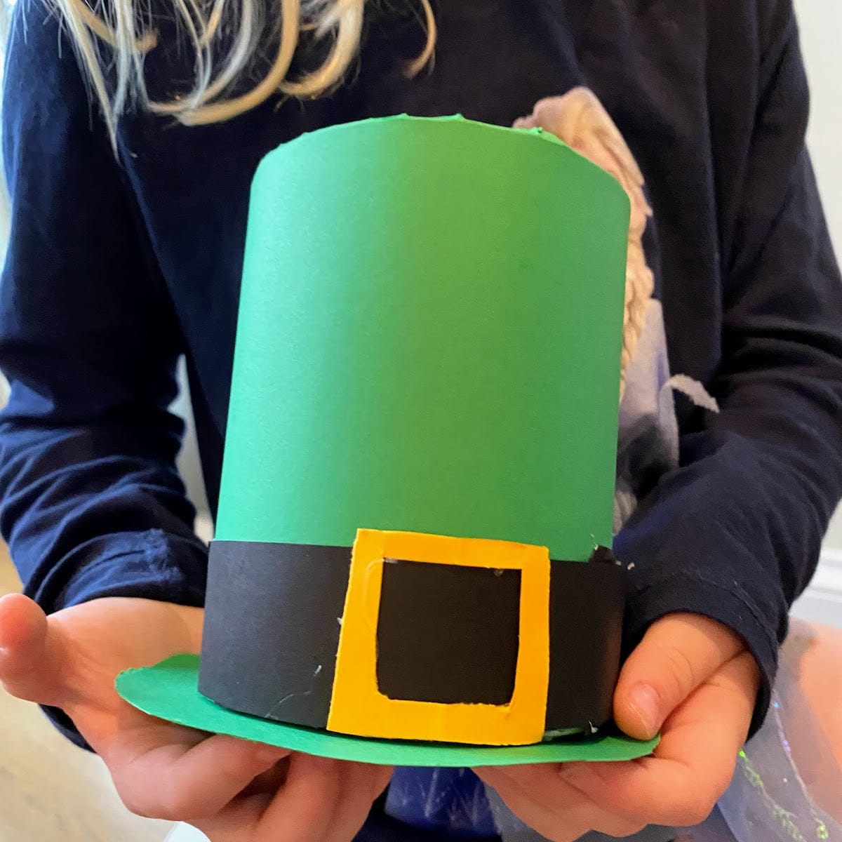 child holding green tin can leprechaun hat 